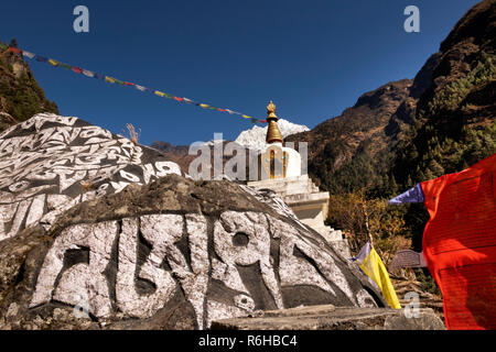 Il Nepal, Benkar, preghiera bandiere buddista intagliato mani di pietra bianca e chorten sotto il monte Kusum Kangkaru Foto Stock