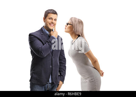 Giovane donna baciando un giovane uomo sulla guancia isolati su sfondo bianco Foto Stock