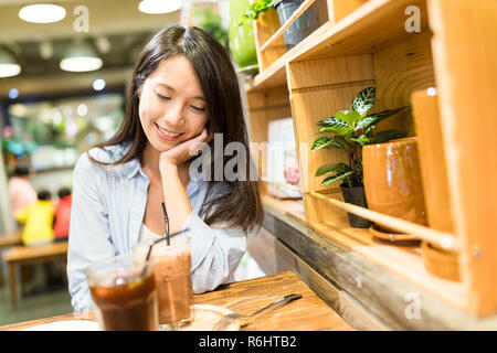 Donna gustare dessert in coffee shop Foto Stock