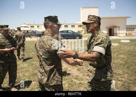 Master Sgt. Jerry C. Giordano, il capo delle operazioni di Special Purpose Marine compito Air-Ground Force-Crisis Response-Africa, si congratula con il Mag. Robert J. Freitas, assistente responsabile dell'aria per SPMAGTF-CR-AF, per la sua promozione al suo rango di corrente dopo Freitas' cerimonia di promozione a Moron Air Base, 20 maggio 2017. La promozione da capitano a major è un cambiamento di grado dalla società-grade officer di campo-grade officer. Foto Stock