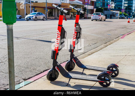 Dicembre 3, 2018 Los Angeles / CA / STATI UNITI D'AMERICA - Salto scooter elettrici parcheggiato su un marciapiede; Jump è un dockless della bicicletta elettrica e scooter sistema di condivisione Foto Stock
