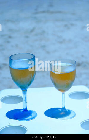 Due bicchieri di birra dal mare. Refrigerate birra in calici sul tavolo al resort sulla costa dell'oceano. Godendo di riposo tropicale. Due bicchieri di birra sulla spiaggia. Refrigerate a Foto Stock