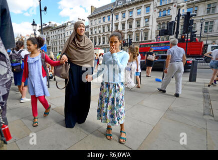 Donna musulmana con le sue due figlie, Londra, Inghilterra, Regno Unito. Foto Stock