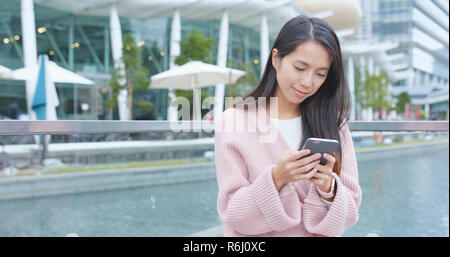 Giovane donna utilizzo del telefono cellulare all'aperto Foto Stock