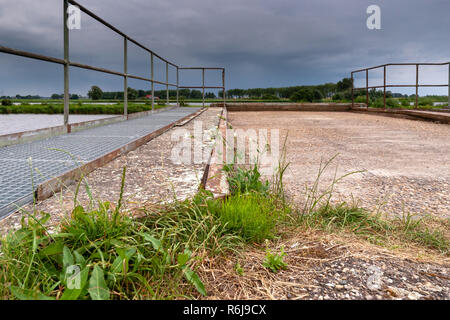 Vecchio e decrepito bastione vintage lungo il lungomare in un fiume landaschap dei Paesi Bassi. Calcestruzzo molo di ormeggio in stato di abbandono. Foto Stock