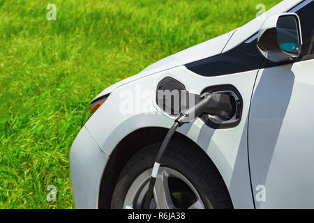 Auto elettrica la carica sul parcheggio. Eco auto. Foto Stock