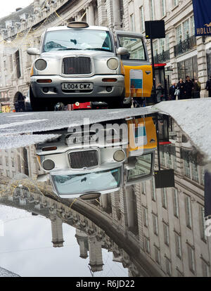 Londra, Regno Unito. 5 Dic, 2018. Un riflesso di un taxi a Londra in una grande pozza di acqua presso il Regent Street. Credito: Dinendra Haria/SOPA Immagini/ZUMA filo/Alamy Live News Foto Stock