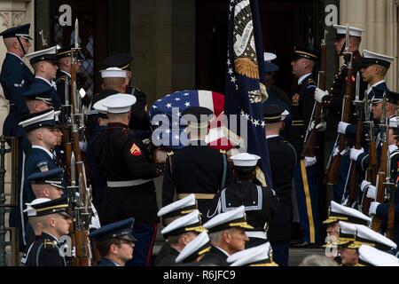 Servizio congiunto pallbearers portare la bandiera-drappeggiato scrigno di ex presidente George H.W. Bush come si arriva per i funerali di Stato presso la Cattedrale Nazionale il 5 dicembre 2018 a Washington, DC. Bush, la quarantunesima edizione del presidente, morì nella sua casa di Houston all'età 94. Foto Stock