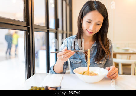 Donna godere di tagliatelle in ristorante Foto Stock