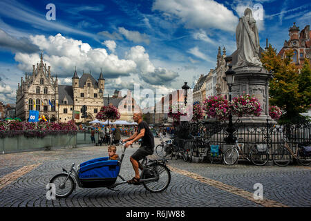 Famiglia fashion bicycle passando davanti al Grote Markt (piazza principale), Mechelen, Belgio Foto Stock