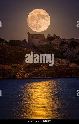 Luna piena al di sopra del vecchio castello in Costa Brava in un villaggio vacanze Fosca , Spagna Foto Stock
