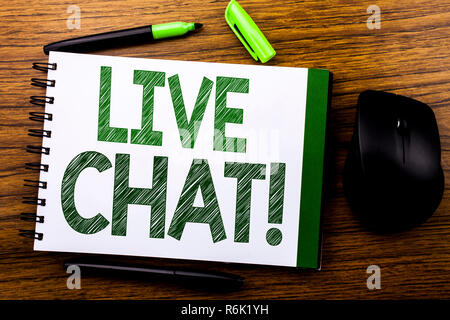 Annuncio della scrittura testo che mostra Live Chat . Il concetto di business per la comunicazione Livechat scritto sul libro dei notebook nota la carta sullo sfondo di legno. Parola verde lettere. Accanto al mouse. Foto Stock