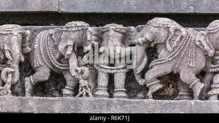 Belur, Karnataka, India - 2 Novembre 2013: Chennakeshava Tempio. Primo piano della parte di pietra grigia linea di sculture di elefanti. Foto Stock