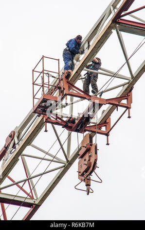 Rotterdam, Paesi Bassi, 28 agosto 2018: vista dal basso verso due lavoratori edili sul traliccio orizzontale di una gru a torre Foto Stock