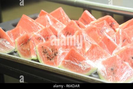 Un vassoio di appena avvolto anguria attende di essere portato alla linea di servizio 24 maggio 2017, a Kadena Air Base, Giappone. La frutta e la verdura fresca sono disponibili per i clienti al DIFAC oltre a che cosa è servito in linee principali. "Go Green" programma mira a evidenziare le diverse di calorie, grassi e proteine contenuti di molti alimenti disponibili presso la DFAC, consentendo ai membri del servizio di prendere decisioni più informate su alimenti che scegli. Foto Stock