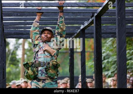 In Ghana, Forze Armate Sgt. Ibrahim Abubakari attraversa un ostacolo durante il regno Accord 2017 alla guerra nella giungla in scuola Achiase base militare, Akim Oda, Ghana, 20 maggio 2017. La Guerra nella Giungla Scuola è una serie di situazionale esercizi di formazione progettate per formare i partecipanti in counter-insorgenza interna e delle operazioni di protezione. Foto Stock