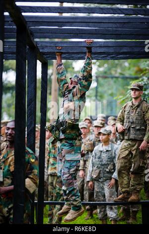 In Ghana, Forze Armate Sgt. Ibrahim Abubakari attraversa un ostacolo durante il regno Accord 2017 alla guerra nella giungla in scuola Achiase base militare, Akim Oda, Ghana, 20 maggio 2017. La Guerra nella Giungla Scuola è una serie di situazionale esercizi di formazione progettate per formare i partecipanti in counter-insorgenza interna e delle operazioni di protezione. Foto Stock