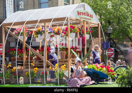 Holland, Michigan, Stati Uniti-5/14/2017: Broeikas serra galleggiante con fiori e le ragazze ad una parata nel centro di Holland, Michigan. Foto Stock