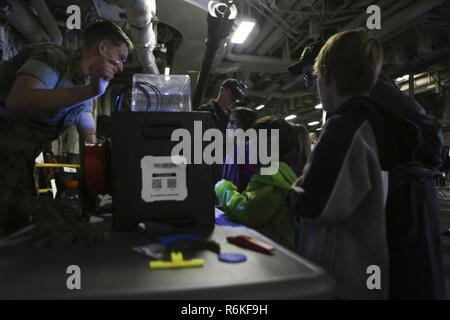 Visitatori check out la stampante 3D sul display a bordo della USS Kearsarge (LHD-3) durante la settimana della flotta di New York, 25 maggio 2017. Stati Uniti Marines, marinai e la costa guardie sono a New York per interagire con il pubblico e dimostrare le funzionalità e insegnare alla gente di New York circa l'America servizi marittimi. Foto Stock