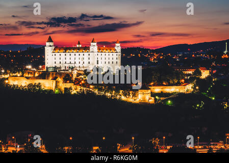 Notte cityscape di castello di Bratislava a destra dopo il tramonto nel giorno di estate; Majestic Palace situato in cima alla collina recintata con pareti pesanti; uno dei Foto Stock