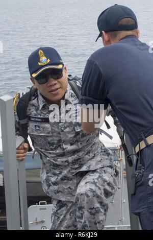 PHUKET, Tailandia (25 maggio 2017) Marina Militare tailandese Capt. Jiramet schede Sanitwong Arleigh Burke-class guidato-missile destroyer USS Sterett (DDG 104) durante un trasferimento di personale in anticipo di Sterett la partecipazione a esercitare il custode del mare. Sterett è parte della superficie Sterett-Dewey Action Group ed è il terzo gruppo di distribuzione che operano sotto il comando ed il controllo costrutto denominato 3a flotta in avanti. Stati Uniti 3a flotta operante in avanti offre opzioni aggiuntive per la flotta del Pacifico commander sfruttando le capacità del 3° e 7° flotte. Foto Stock