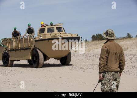 VENTSPILS, Lettonia- marinai con unità Beachmaster due, Navale Beach gruppo due, Expeditionary Strike gruppo due, azionare più leggero di rialimentazione anfibio Cargo 5 ton in preparazione per esercitare Saber Strike 17 in Ventspils, Lettonia, 22 maggio 2017. Esercizio Saber Strike 17 è un annuale combinati-esercizio congiunto condotti presso varie sedi in tutta la regione del Mar Baltico e della Polonia. La combinazione di corso di formazione prepara gli alleati e partner per rispondere più alle crisi regionali e di soddisfare le loro esigenze di sicurezza mediante il miglioramento della sicurezza delle frontiere e la lotta contro le minacce. Foto Stock