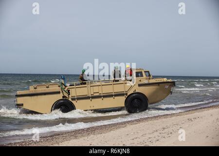 VENTSPILS, Lettonia- marinai con unità Beachmaster due, Navale Beach gruppo due, Expeditionary Strike gruppo due, azionare più leggero di rialimentazione anfibio Cargo 5 ton in preparazione per esercitare Saber Strike 17 in Ventspils, Lettonia, 22 maggio 2017. Esercizio Saber Strike 17 è un annuale combinati-esercizio congiunto condotti presso varie sedi in tutta la regione del Mar Baltico e della Polonia. La combinazione di corso di formazione prepara gli alleati e partner per rispondere più alle crisi regionali e di soddisfare le loro esigenze di sicurezza mediante il miglioramento della sicurezza delle frontiere e la lotta contro le minacce. Foto Stock