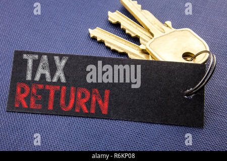 Il testo scritto a mano che mostra il ritorno fiscale. Il concetto di Business iscritto per la Fiscalità rimborso scritta sulla carta nota collegata al tasto, sfondo nero con spazio vicino fino Foto Stock