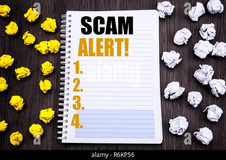 Conceptual la scrittura a mano didascalia di testo mostra Scam Alert. Il concetto di business per Avviso di frode scritto su blocco note nota notebook libro sullo sfondo di legno con sticky ripiegato in giallo e bianco Foto Stock