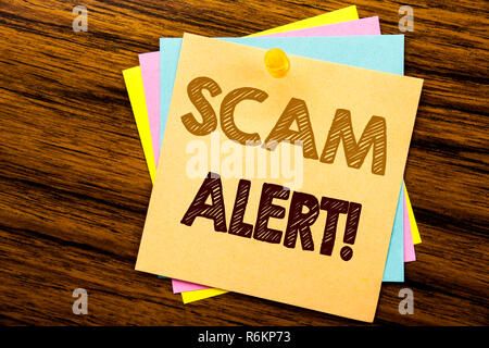 Mano concettuale di scrittura di testo Didascalia ispirazione mostra Scam Alert. Il concetto di business per Avviso di frode scritto su una nota adesiva carta sullo sfondo di legno. Foto Stock