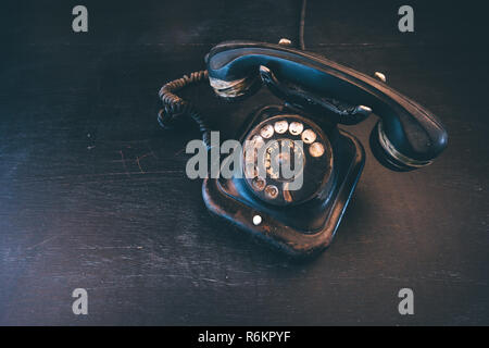 Vintage nero telefono fisso, vecchio e stagionato. Rotto il concetto di comunicazione. Foto Stock