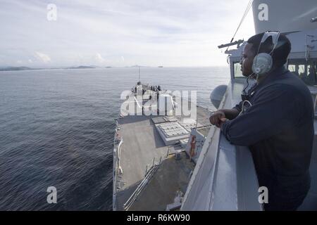 PHUKET, Tailandia (21 maggio 2017) Intendente di terza classe Atonyo Wilson, a Jacksonville, North Carolina native, sorge guarda a bordo Arleigh Burke-class guidato-missile destroyer USS Sterett (DDG 104) come la nave si prepara per ancorare al largo della costa della Thailandia per una porta programmata visita. Sterett è parte della superficie Sterett-Dewey Action Group ed è il terzo gruppo di distribuzione che operano sotto il comando ed il controllo costrutto denominato 3a flotta in avanti. Stati Uniti 3a flotta operante in avanti offre opzioni aggiuntive per la flotta del Pacifico commander sfruttando le capacità del 3° e 7° flotte. Foto Stock