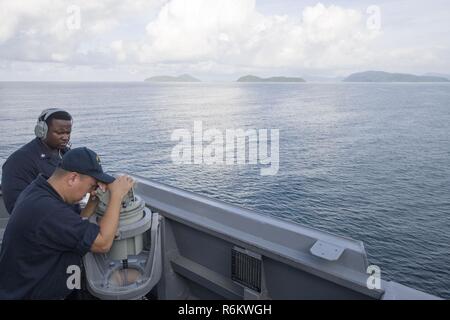 PHUKET, Tailandia (21 maggio 2017) Capo Quartermaster David Arriola, un El Paso, Texas native, guarda attraverso un alidada telescopico come intendente di terza classe Atonyo Wilson, a Jacksonville, North Carolina native, comunica i cuscinetti a bordo Arleigh Burke-class guidato-missile destroyer USS Sterett (DDG 104) come la nave si prepara per ancorare al largo della costa della Thailandia per una porta programmata visita. Sterett è parte della superficie Sterett-Dewey Action Group ed è il terzo gruppo di distribuzione che operano sotto il comando ed il controllo costrutto denominato 3a flotta in avanti. Stati Uniti 3a flotta operante in avanti offre ad Foto Stock