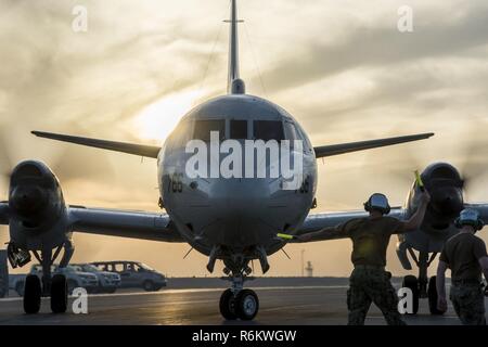 DOHA, Qatar (6 maggio 2017) Aviazione meccanico strutturale di seconda classe Nathan Tharas di Patrol Squadron (VP) 46 dirige un P-3C Orion aeromobile come esso appoggia nel proprio posto di parcheggio a bordo Al Udeid Air Base. VP-46 è attualmente implementata in 5th, sesto e settimo flotta aree di responsabilità a sostegno di funzionamento inerenti a risolvere e ridare speranza. Foto Stock