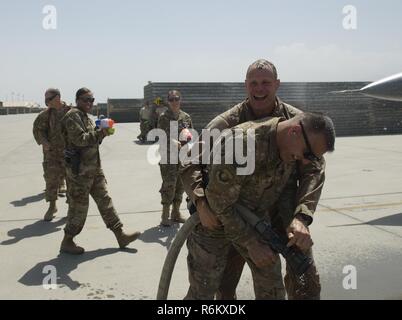 Brig. Gen. Jim Sears, comandante della 455th Air Expeditionary Wing, combatte una manichetta antincendio lontano dal Chief Master Sgt. Peter Speen, capo del comando della 455th AEW, dopo aver completato i suoi fini volo a Bagram Airfield, Afghanistan, 22 maggio 2017. Sears, che ha comandato il 455th AEW per gli ultimi dodici mesi, è un comando pilota con più di 3.200 ore di volo, comprese le missioni di combattimento in Iraq e in Afghanistan. Foto Stock