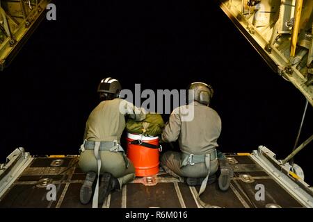 Petty Officer 2a classe Mandi Stevens e sottufficiali di 2a classe di Chris Parmenter, aviazione di tecnici di manutenzione dalla guardia costiera Stazione aria Barbieri punto, sedersi sulla rampa di un HC-130 Hercules aereo per distribuire un intervallo lungo dispiegabile kit di discesa ad un recipiente di disabili circa 80 miglia fuori della Tonga Maggio 25, 2017. L'aria equipaggio stava tornando da una ricerca e soccorso conferenza in Nuova Zelanda e macchiato il recipiente dopo essere stato deviato. Foto Stock