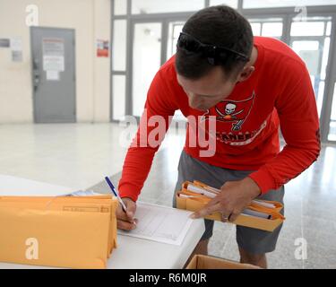 Stati Uniti Air Force Staff Sgt. Daniel Adams, strutturali artigiano assegnato al 379 Expeditionary Ingegneria Civile Squadron, offre completato donatore di midollo osseo kit di registrazione per il donatore di midollo osseo registration desk Al Udeid, Air Force Base in Qatar, 19 maggio 2017. I kit sono stati distribuiti in base ai singoli squadroni come parte di una vasta base di auto che si terrà a sostegno di una forza militare focalizzata donatore di midollo osseo registro che include il militare degli Stati Uniti e i membri delle loro famiglie e DoD i dipendenti civili di età compresa tra i 18 e 60 e i cui i donatori sono poi aggiunti alla Nazionale Ma Foto Stock