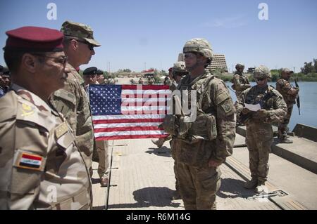 Stati Uniti Esercito il Mag. Gen. Giuseppe Martin, il comandante generale combinata di forze congiunte terra comando di componente e 1a divisione di fanteria, promuove il Mag. Timothy Batig, assegnati al 2° Battaglione, 2° Brigata Team di combattimento, ottantaduesima Airborne Division, per il grado di tenente colonnello al fianco di iracheni e i partner della coalizione a Mosul, Iraq, 25 maggio 2017. La seconda BCT, ottantaduesima Abn. Div., consente loro ISF partner attraverso il consigliare e assistere la missione, contribuendo pianificazione, raccolta di intelligence e di analisi, forza di protezione, e gli incendi di precisione per ottenere la sconfitta militare di Iside. CJTF-funzione OIR è il global Co Foto Stock