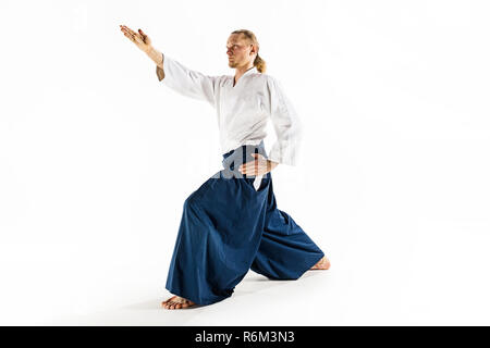 Aikido pratiche master di difesa. Uno stile di vita sano e sport concetto. Uomo con la barba in kimono bianco su sfondo bianco. Foto Stock