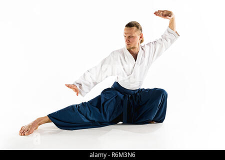 Aikido pratiche master di difesa. Uno stile di vita sano e sport concetto. Uomo con la barba in kimono bianco su sfondo bianco. Foto Stock