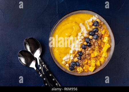 Vista superiore del frullato di mango ciotola con frutti Foto Stock