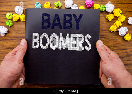 La parola, la scrittura Baby Boomer. Il concetto di business per la generazione di dati demografici scritto sul notebook notepad libro sul legno in legno con uno sfondo imprenditore man mano e dito. Foto Stock