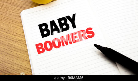 Mano concettuale di scrittura di testo Didascalia ispirazione che mostra i baby boomer. Il concetto di business per la generazione di dati demografici scritto su notebook, copia dello spazio sul libro lo sfondo con il pennarello indelebile Foto Stock