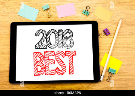 La scrittura di un testo che mostra 2018 Migliore. Il concetto di business per scelta recensione scritta su tablet portatile, sullo sfondo di legno con una nota adesiva e penna Foto Stock