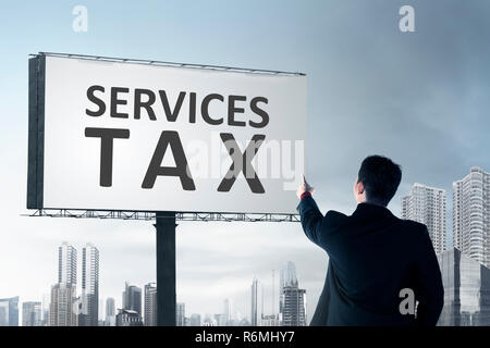 Vista posteriore di imprenditore puntando al cartellone con i servizi segno fiscale Foto Stock