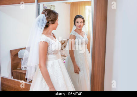 Sposa in abito bianco guardando nello specchio Foto Stock