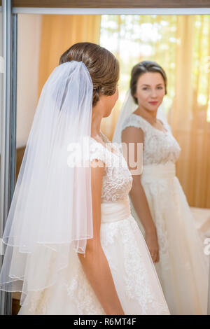 Sposa in abito bianco guardando nello specchio Foto Stock