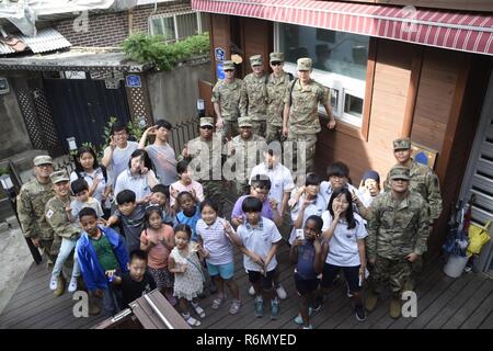 Stati Uniti I soldati e il coreano Augmentees per l' esercito degli Stati Uniti ha assegnato al trentacinquesimo difesa aerea della brigata di artiglieria e i bambini e il personale del locale di Pyeongtaek Centro per l'infanzia, scattare una foto 30 Maggio 2017 durante la comunicazione alla comunità evento. Foto Stock