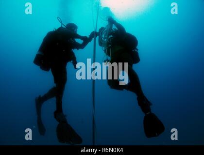 Utilitiesman 2a classe Erick Martin e costruzione elettricista 2a classe Greg Lewis, assegnato alla costruzione subacquea Team (UCT) 2, prepararsi a rig un profondo acqua boa di ormeggio in Apra Harbor al largo di Guam Maggio 31, 2017. UCT 2 fornisce ottime inshore sottomarino e capacità di costruzione sotto la guida del comandante, Task Force 75. Essi sono in grado di costruire, ispezionare, riparare e manutenere ocean impianti nonché sistemi subacquei. Foto Stock