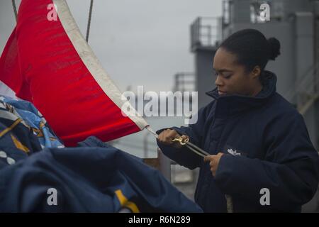 Oceano Pacifico (31 maggio 2017) Quartermaster 2a classe Kelly Perlote, un nativo di Philadelphia, assegnato al dipartimento amministrativo del dock anfibio sbarco nave USS Pearl Harbor (LSD 52), gestisce le bandiere del segnale sulla nave del ponte di segnale. Pearl Harbor è attualmente in corso condurre un esercizio di certificazione (CERTEX) come parte della terza ed ultima fase di qualificazione per la loro prossima distribuzione. L'America pronto anfibio gruppo è composto di più di 1.800 marinai e 2.600 marines assegnato all'assalto anfibio nave USS America (LHA 6), il trasporto anfibio nave dock Foto Stock